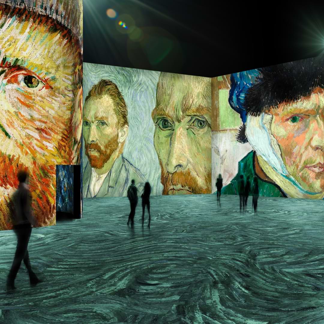 Van Gogh's various portraits illuminated around the exhibition as people walk through and around them.
